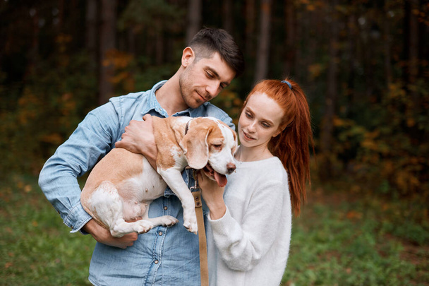 handsome man holding his dog, introducing it with his girl - Fotografie, Obrázek