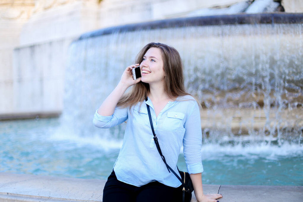 Mladá dívka mluví o smartphone v pozadí fontána di Trevi. - Fotografie, Obrázek