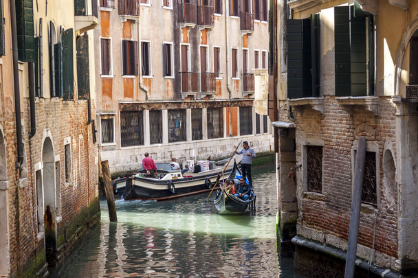Tourists travel on gondolas at canal - Venice, Italy. - Фото, изображение