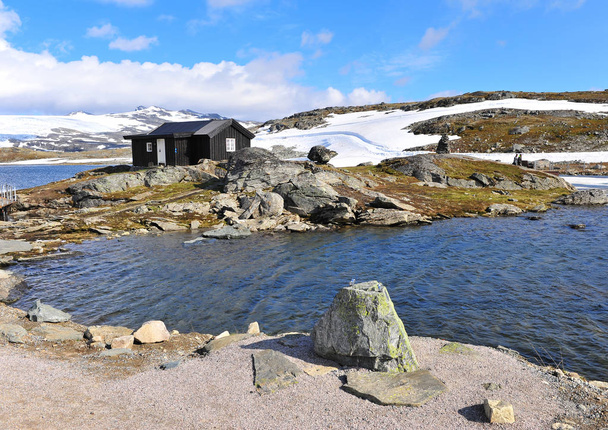 Paysage nordique enneigé avec maison noire sur le lac
 - Photo, image