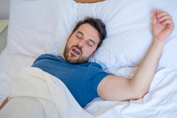Koncepcja problem chrapania. Mężczyzna w łóżku, chrapanie i spanie - Zdjęcie, obraz