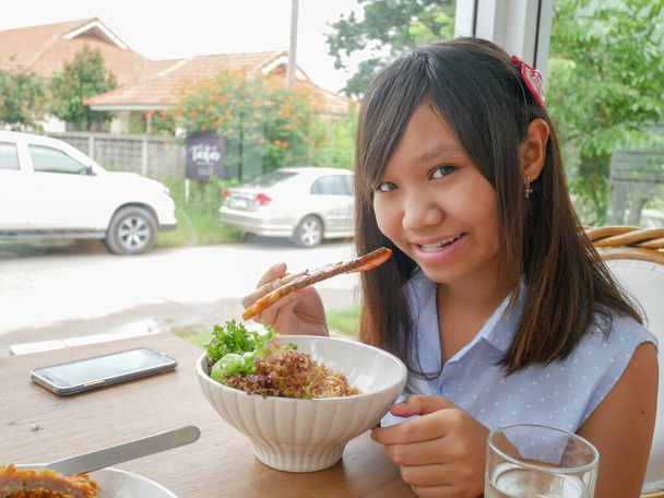 Pirinçli somon ızgarası yiyen kız.. - Fotoğraf, Görsel