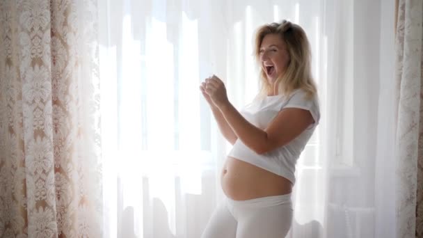 glückliche Schwangere mit nacktem Bauch bewundert Ultraschallbild Säugling - Filmmaterial, Video