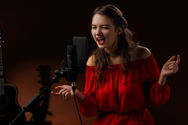 Singer in front of a microphone while recording a song - Foto, Bild