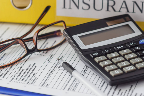 Clean insurance form, folders, pen, glasses and calculator - Foto, Bild