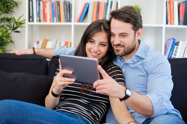 Νεαρό ζευγάρι βλέποντας περιεχομένου πολυμέσων στο διαδίκτυο σε ψηφιακή δισκίο - Φωτογραφία, εικόνα