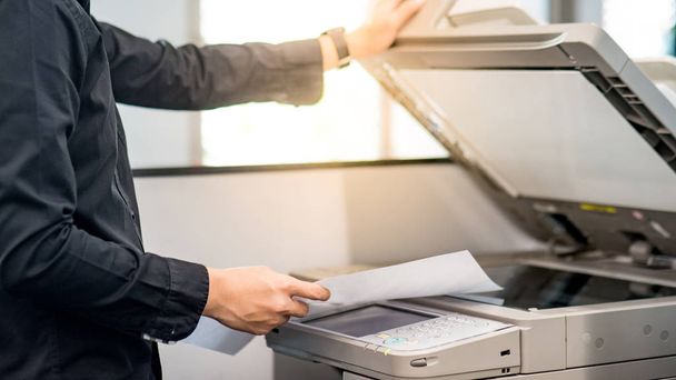 Homme d'affaires utilisant un photocopieur au bureau
 - Photo, image