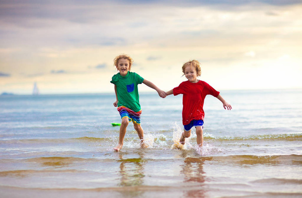 A gyerekek játszanak, trópusi tengerparton. Homok- és vízi játék. - Fotó, kép