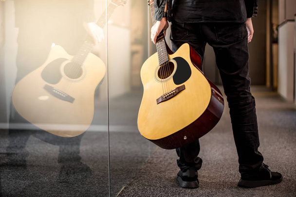 Guitarrista masculino segurando guitarra acústica
 - Foto, Imagem