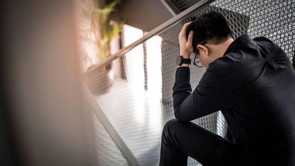 Asian man feeling stressed sitting on stair - Photo, Image