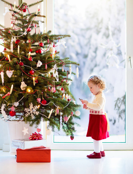 Child decorating Christmas tree. Kid on Xmas eve. - Fotó, kép