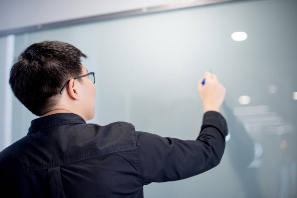 Asian businessman writing on whiteboard - Фото, зображення