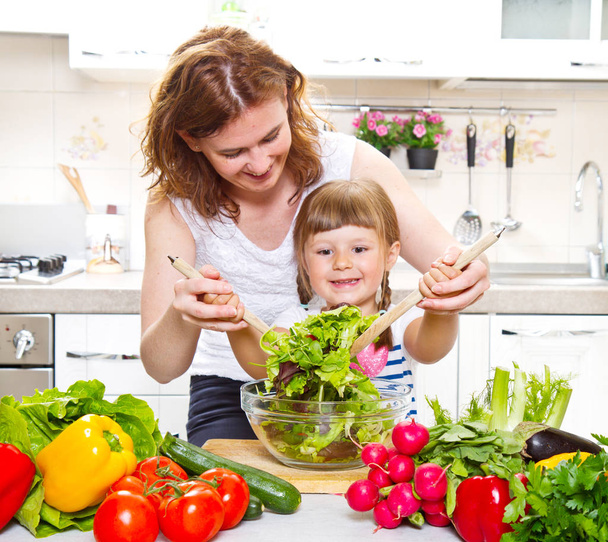 Mother and daughter cooking dinner in kitchen - Photo, Image