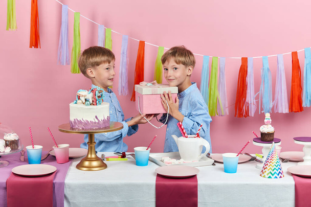two cute handsome little boys preparing a gift for their friend, surprise - Foto, Bild