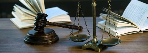 Hukuk ve Adalet sembolleri ahşap masa üzerinde bulanık kitap arkaplanı. - Fotoğraf, Görsel