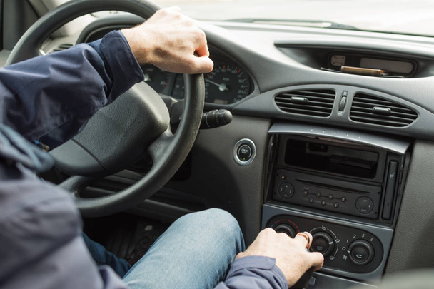 Hands of a driver on steering wheel of a car. - Фото, зображення