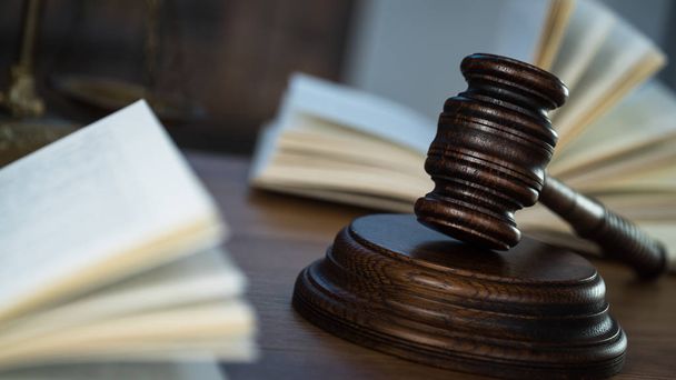 Hukuk ve Adalet sembolleri ahşap masa üzerinde bulanık kitap arkaplanı. - Fotoğraf, Görsel