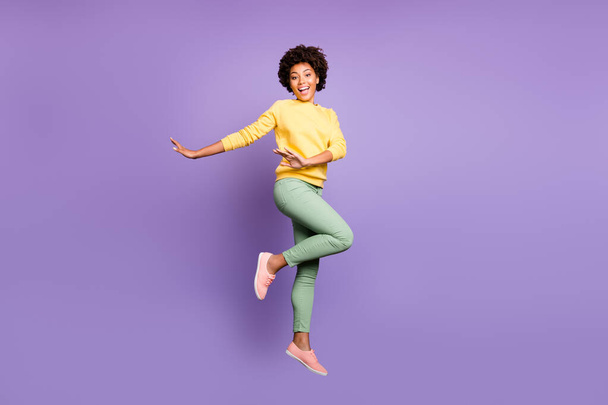 Full length photo of funky funny brunette curly hair afro american girl dance fun on fall spring vacation free time feel candid jump wear casaul style outfit isolated violet purple color background - Valokuva, kuva