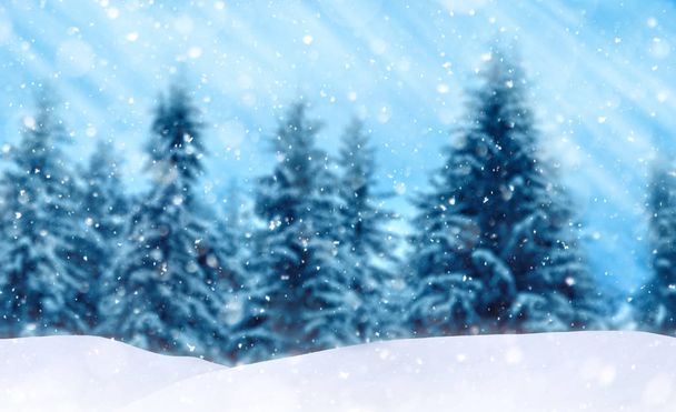 Zimowy krajobraz z zamglonym śnieżnym lasem, błękitnym niebem i opadami śniegu - Zdjęcie, obraz