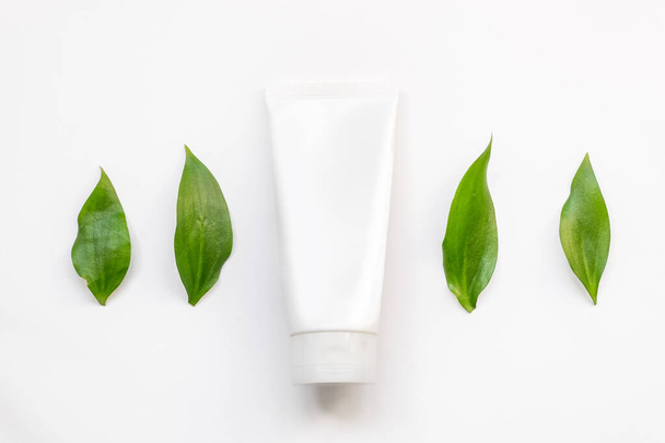 Embalaje cosmético orgánico natural maqueta de plástico con hojas. Botella simulada para branding
. - Foto, Imagen