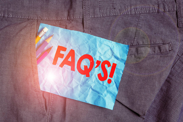 Znak tekstowy pokazujący FAQ S. koncepcyjna lista zdjęć pytań i odpowiedzi odnoszących się do konkretnego przedmiotu sprzęt do pisania i niebieski papier notatki wewnątrz kieszeni mężczyzn spodnie robocze. - Zdjęcie, obraz