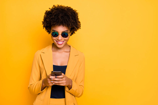 Close-up portrait of her she nice attractive lovely focused cheerful cheery addicted wavy-haired girl using cell browsing web 5g app isolated on bright vivid shine vibrant yellow color background - Foto, Imagen