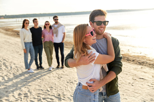 happy couple and group of friends on summer beach - Фото, изображение