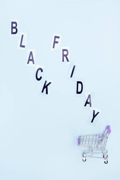 Shopping basket and the inscription black friday on a blue background. - Photo, image