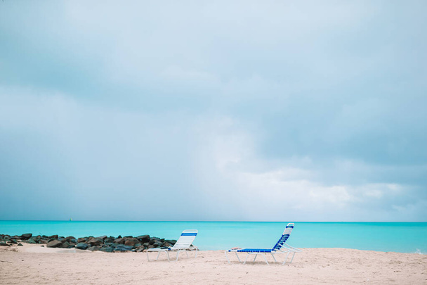 Λευκά lounge καρέκλες σε μια όμορφη τροπική παραλία στις Μαλδίβες - Φωτογραφία, εικόνα