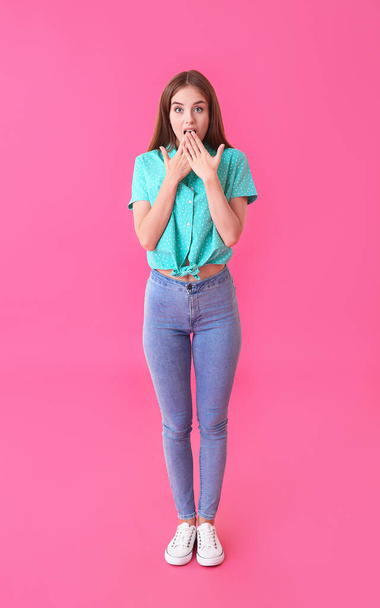 Surprised young woman on color background - Photo, image