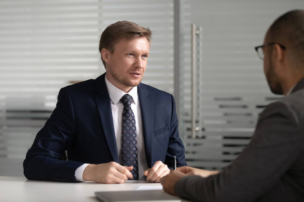 Confident businessman candidate answering recruiter questions at interview - Fotó, kép