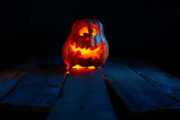 Scary Halloween pumpkins on wood in a spooky place at night. Poster concept - Foto, Imagen
