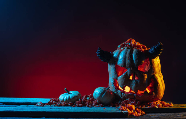 Scary Halloween pumpkins on wood in a spooky place at night. Poster concept - Photo, image