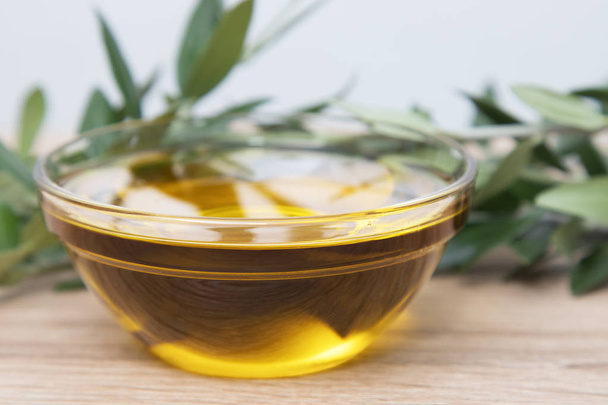 natural olive oil in glass container with olive branches - 写真・画像
