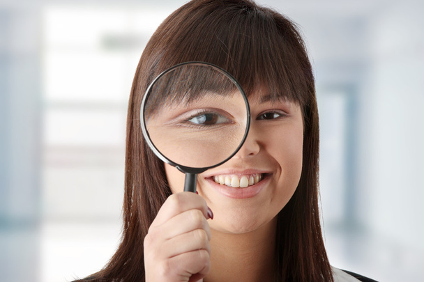 Business woman looking into a magniying glass - Photo, Image