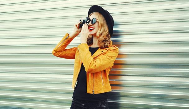 Stylish smiling woman with retro camera taking picture wearing y - Фото, зображення