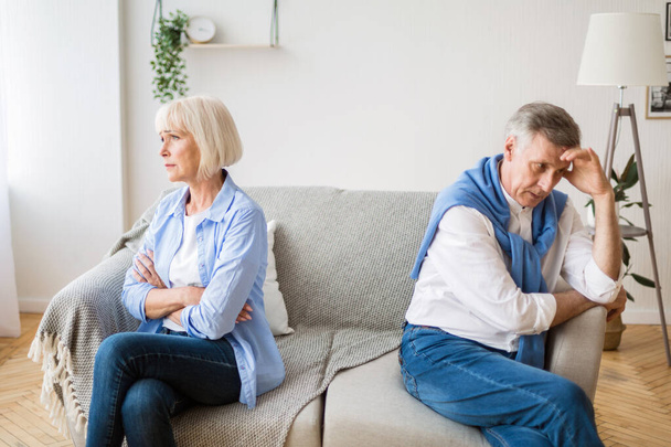 Senior couple after argument sitting on opposite sides of sofa - Photo, Image