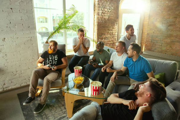 Group of excited friends playing video games at home - Foto, Bild
