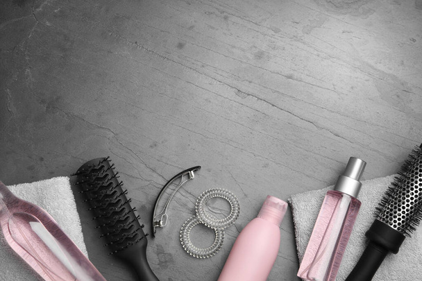 Płaska kompozycja leżakowa z produktów kosmetycznych do włosów i narzędzi na szarym tle. Miejsce na tekst - Zdjęcie, obraz