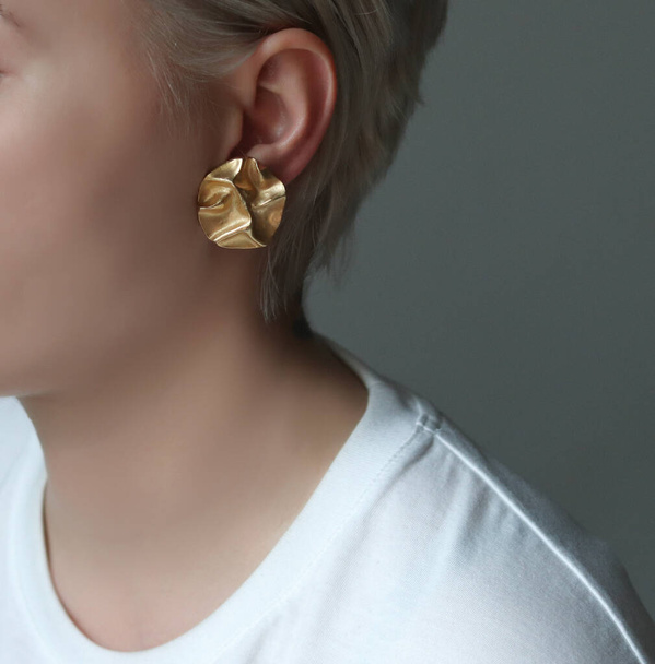 Jewelry in the form of earrings on the girls ear close up - Fotoğraf, Görsel