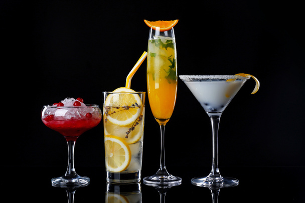 Different tasty cocktails on dark background - Фото, изображение