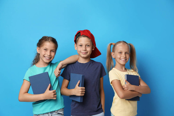 Little children with books on blue background. Reading concept - Fotó, kép