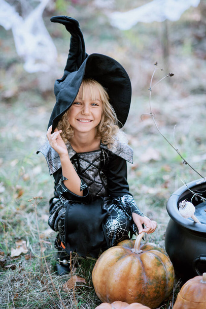 schöne Mädchen Hexe. kleines Mädchen in welchem Kostüm feiern Halloween im Freien und Spaß haben. Kinder tricksen oder behandeln - Foto, Bild
