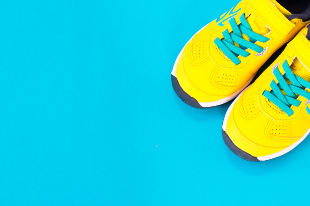 Pair of yellow shoes on blue background. black friday - Photo, Image
