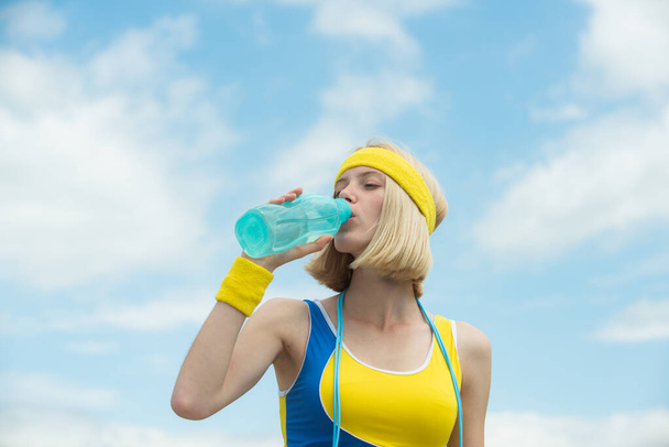 Magabiztos gyönyörű nő edző fitness sport stílusú ruhák iszik vizet. Reggeli edzés. Fitness az utcán. Reggeli edzés. Kiegészítők jógához. - Fotó, kép