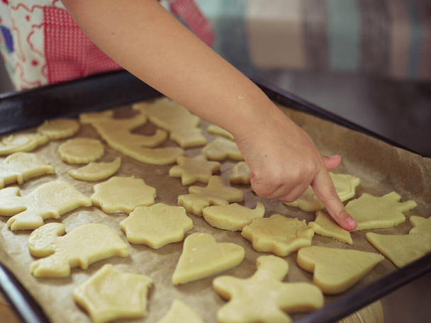a child at home cuts out cookie cutters. - Foto, Imagen