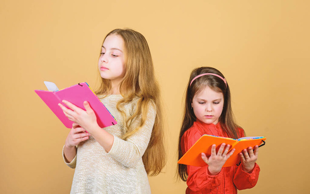 Sisters pick books to read together. Adorable girls love books. Opening doors through literacy. Kids girls with books or notepads. Education and kids literature. Favorite fairytale. Back to school - Φωτογραφία, εικόνα