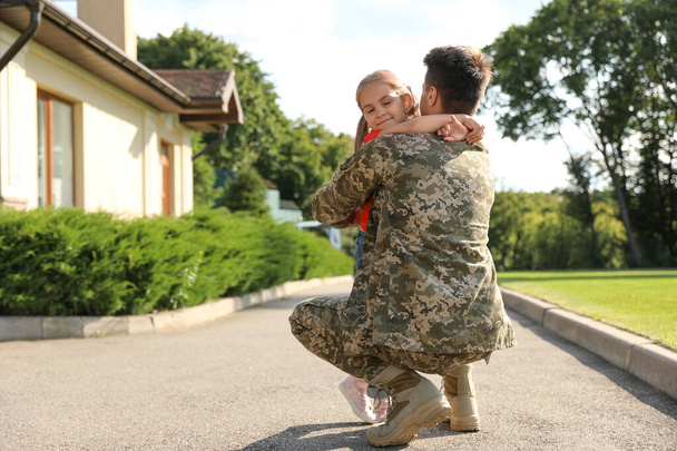 Father in military uniform hugging little daughter outdoors - Foto, afbeelding