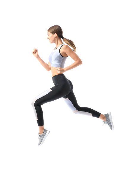 Sporty young woman running against white background - Photo, image