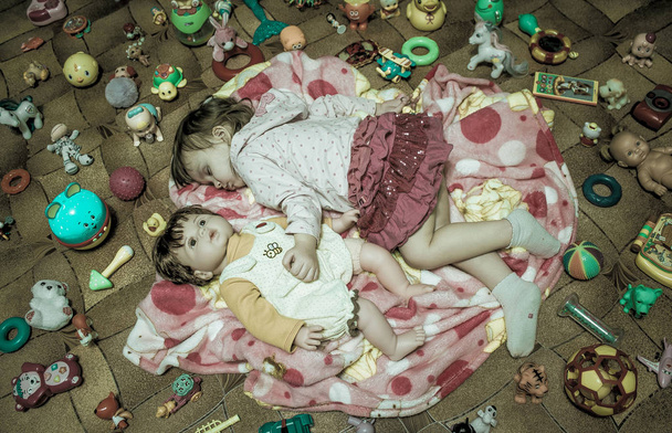 Girl sleeping among toys - Фото, изображение